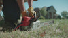 A person starts a chainsaw, then uses it to cut a log